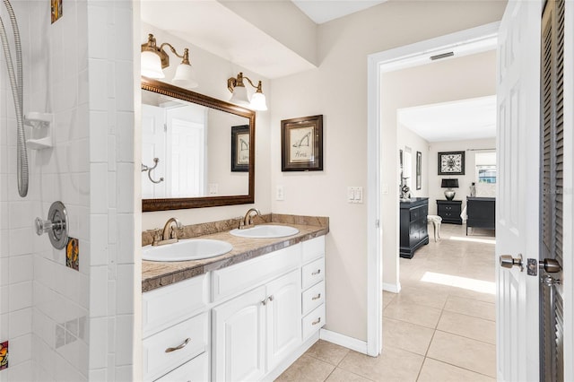 bathroom featuring tile patterned flooring, vanity, and walk in shower