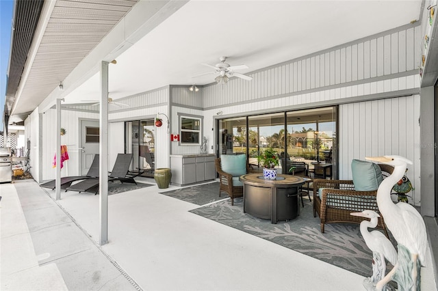 view of patio / terrace with ceiling fan and an outdoor living space with a fire pit