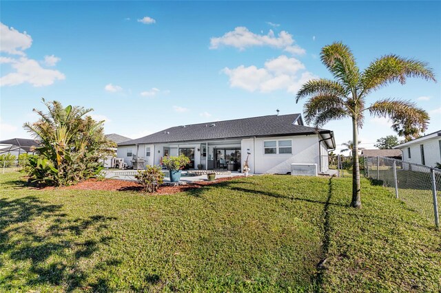 back of property featuring a patio area and a yard