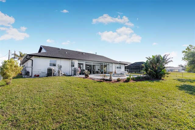 back of house featuring a lawn, a patio area, and a pool