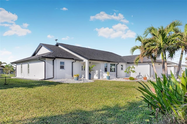 rear view of property featuring a garage and a lawn