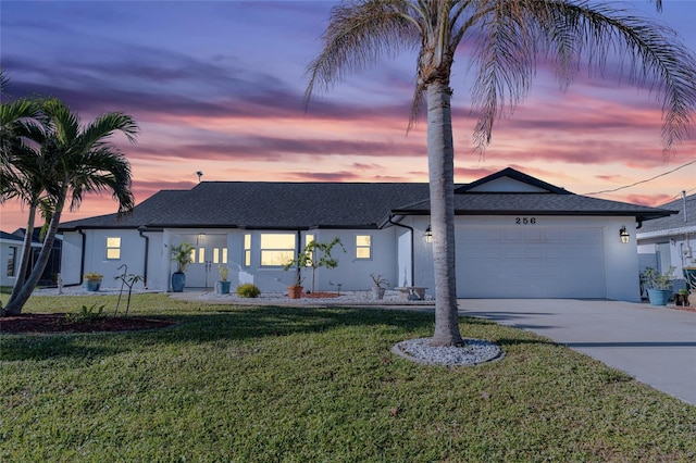 ranch-style house featuring a garage and a yard