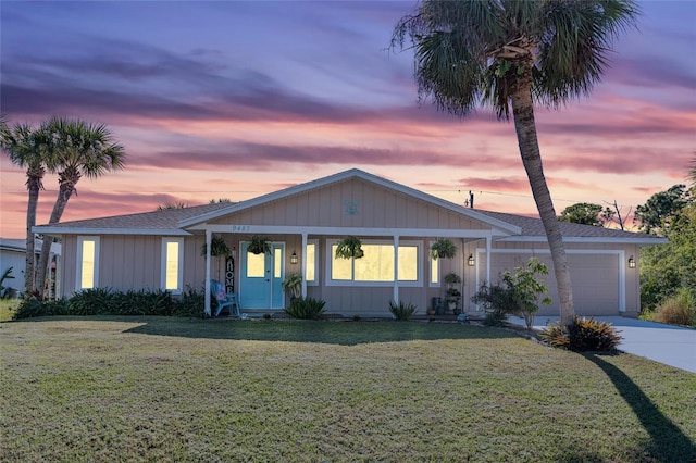 ranch-style home featuring a garage and a lawn