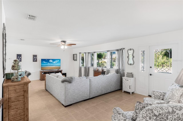 living room featuring ceiling fan and a healthy amount of sunlight