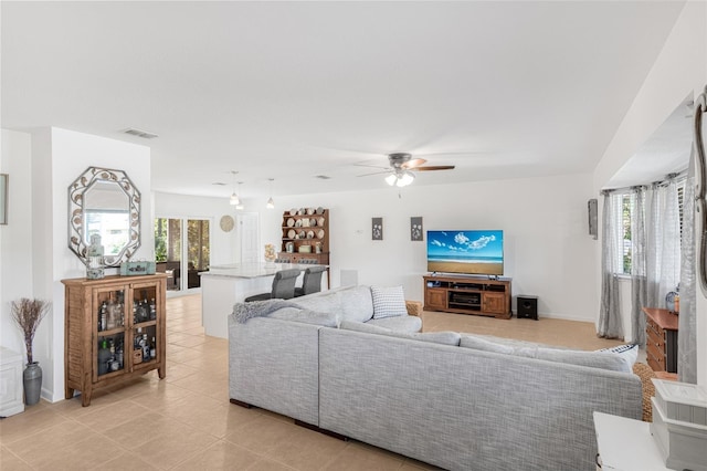 tiled living room featuring ceiling fan