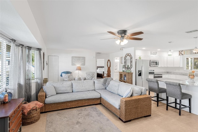 tiled living room featuring plenty of natural light and ceiling fan