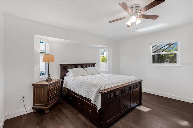 bedroom with dark hardwood / wood-style floors, ceiling fan, and multiple windows