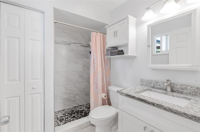 bathroom with tile patterned flooring, vanity, toilet, and walk in shower