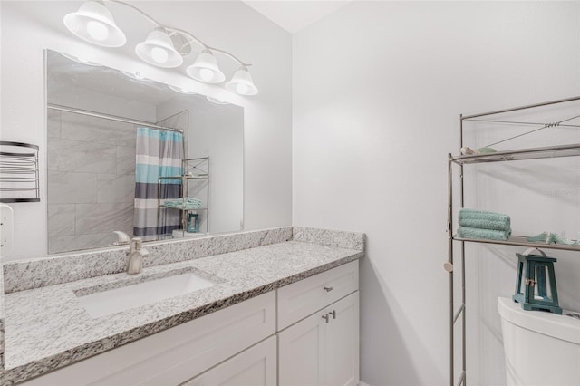 bathroom featuring toilet, vanity, and a shower with shower curtain