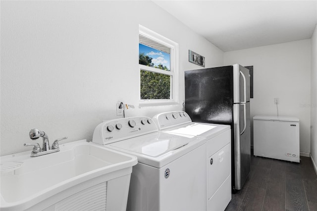 laundry area with dark hardwood / wood-style floors, sink, and washing machine and clothes dryer