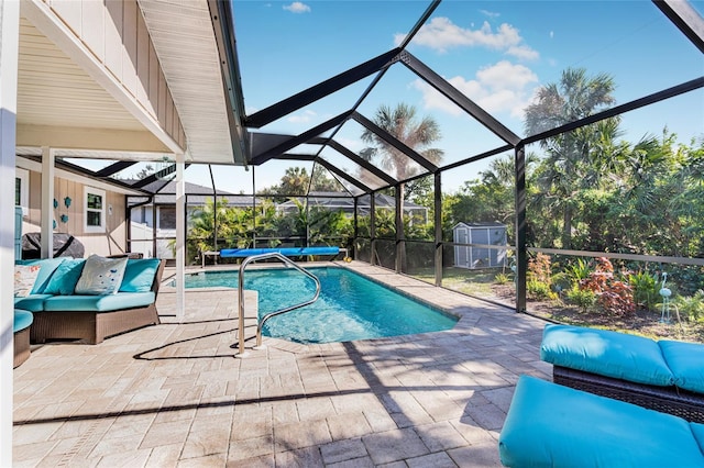 view of pool with glass enclosure, outdoor lounge area, and a patio