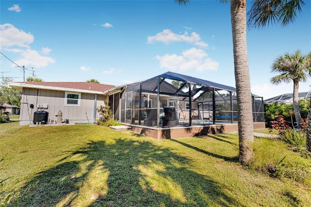 back of house with a lanai and a yard