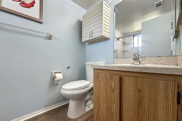 bathroom featuring hardwood / wood-style floors, vanity, toilet, and an enclosed shower