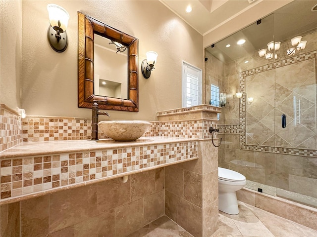 bathroom featuring a tile shower, sink, tile walls, toilet, and tile patterned floors