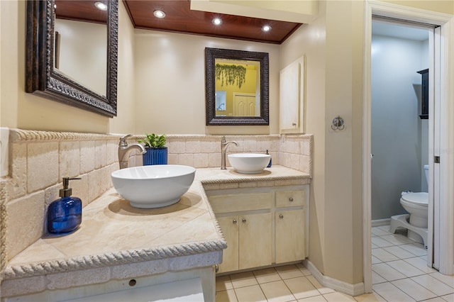 bathroom with vanity, toilet, tile patterned flooring, and decorative backsplash