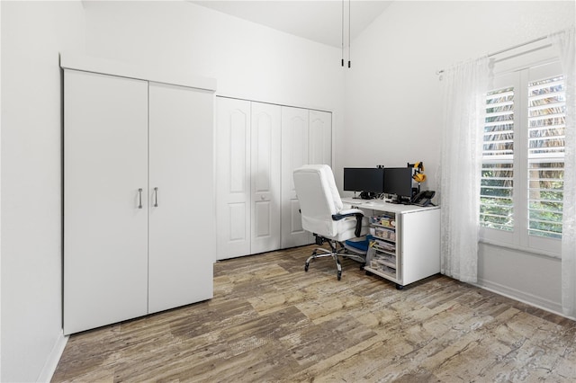 office featuring wood-type flooring and high vaulted ceiling