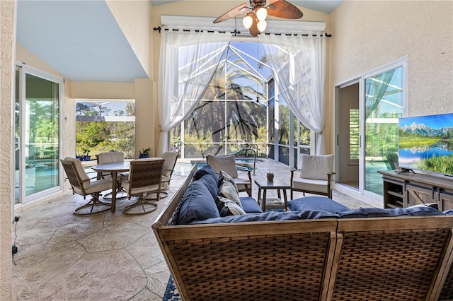 sunroom / solarium with ceiling fan and vaulted ceiling