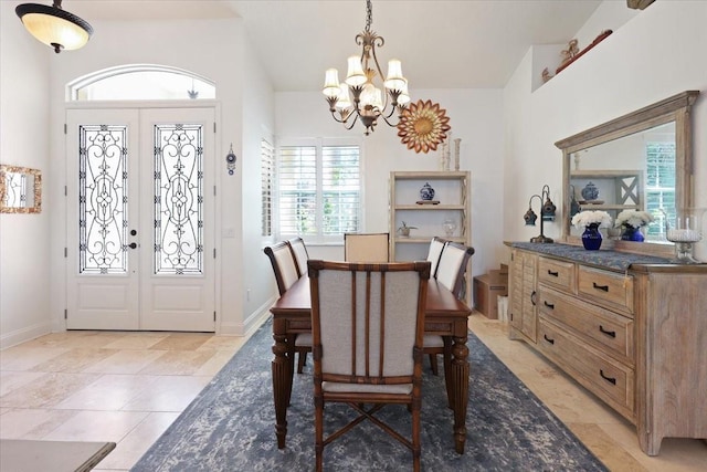 dining space featuring an inviting chandelier, lofted ceiling, and french doors