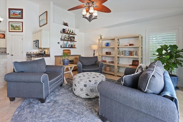 living room with bar area, ceiling fan, and a high ceiling