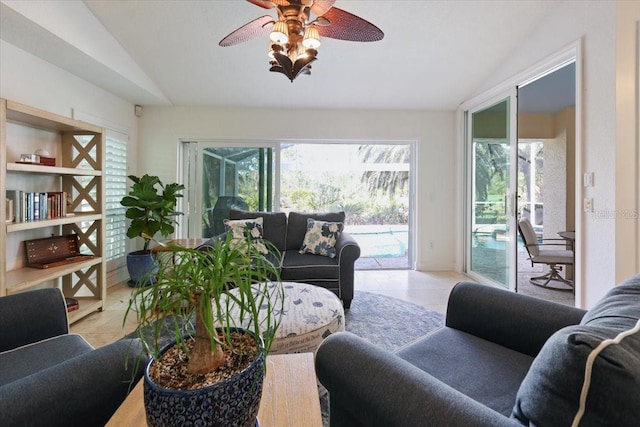 tiled living room with ceiling fan and vaulted ceiling