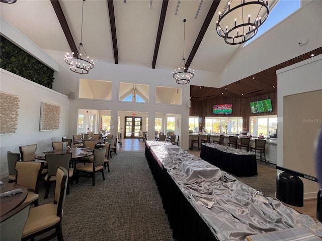 dining space with an inviting chandelier, beam ceiling, high vaulted ceiling, and a healthy amount of sunlight