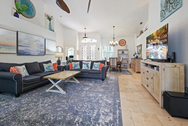 living room with french doors, a towering ceiling, and a notable chandelier