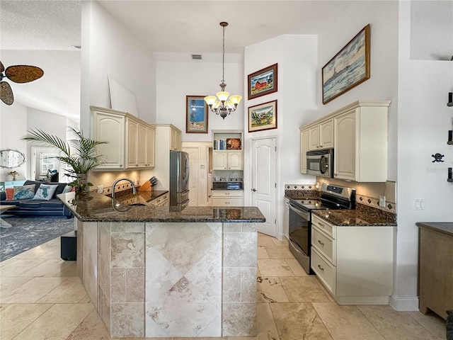 kitchen with pendant lighting, stainless steel appliances, kitchen peninsula, and cream cabinets