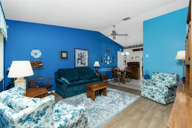 living room with hardwood / wood-style floors, ceiling fan, and vaulted ceiling