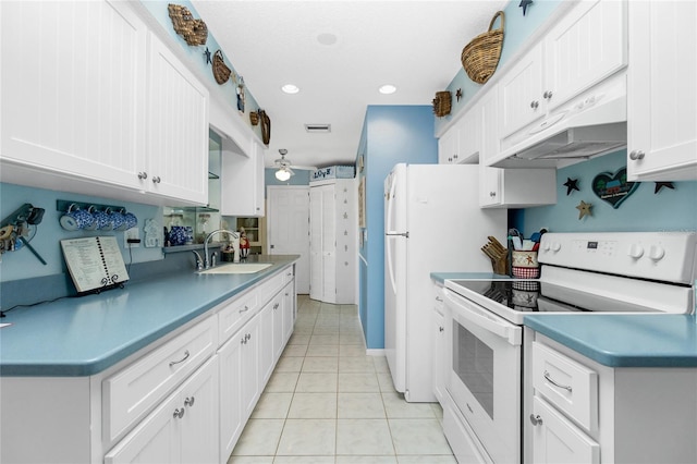 kitchen with white electric range oven, extractor fan, sink, light tile patterned floors, and white cabinetry