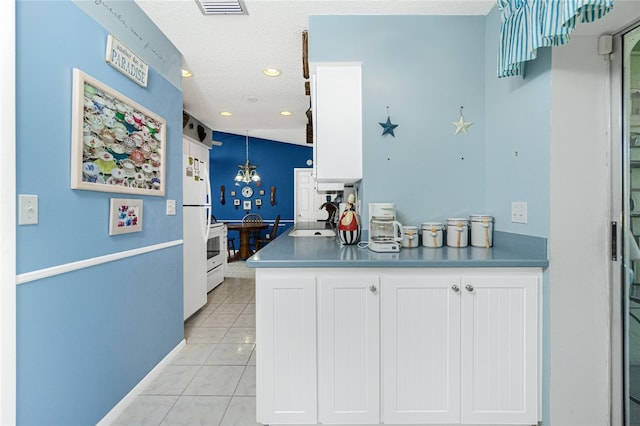 kitchen with white cabinetry, sink, light tile patterned floors, and a textured ceiling