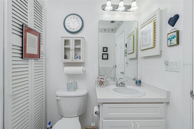 bathroom featuring vanity, a notable chandelier, and toilet