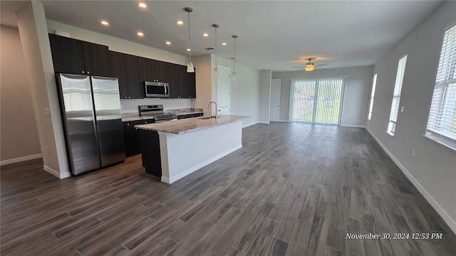 kitchen with decorative light fixtures, sink, stainless steel appliances, and a wealth of natural light