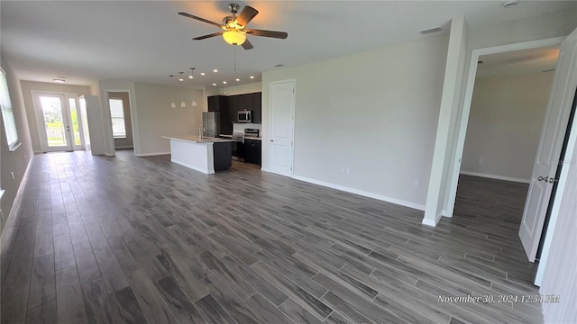 unfurnished living room featuring dark hardwood / wood-style floors, ceiling fan, and sink