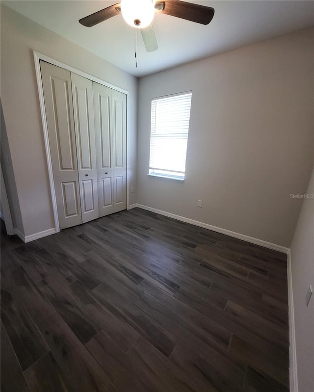 unfurnished bedroom with ceiling fan, dark hardwood / wood-style flooring, and a closet