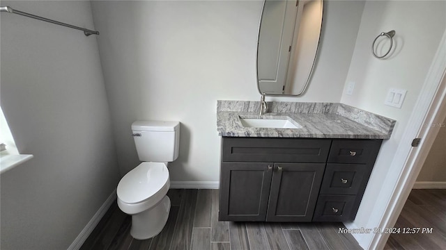 bathroom with vanity, hardwood / wood-style flooring, and toilet