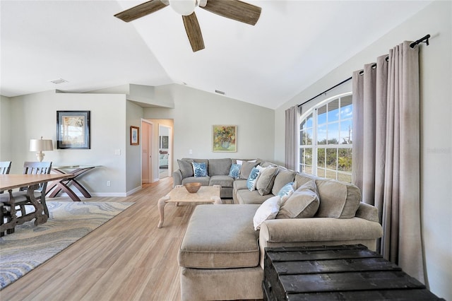 living room featuring ceiling fan, light hardwood / wood-style floors, and vaulted ceiling