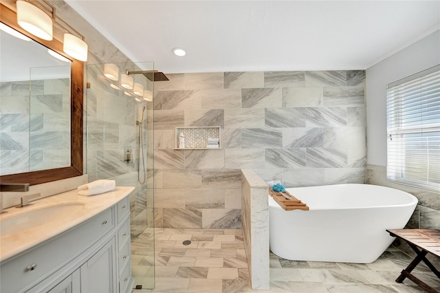 bathroom featuring plus walk in shower, vanity, and tile walls