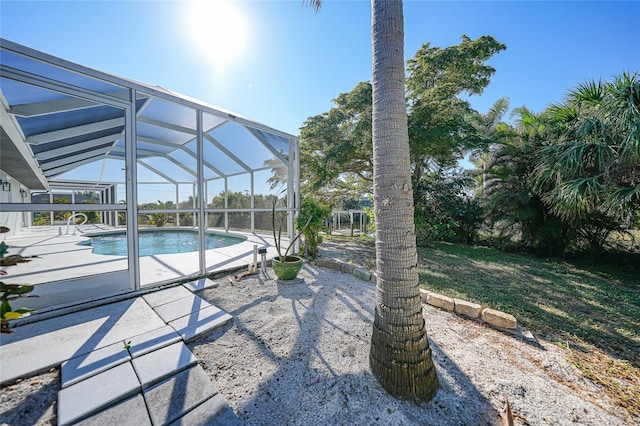 view of swimming pool with glass enclosure and a patio area