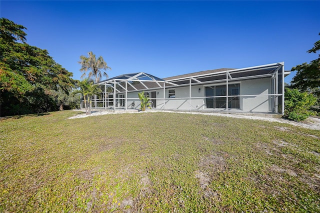 back of house featuring a lawn and a lanai