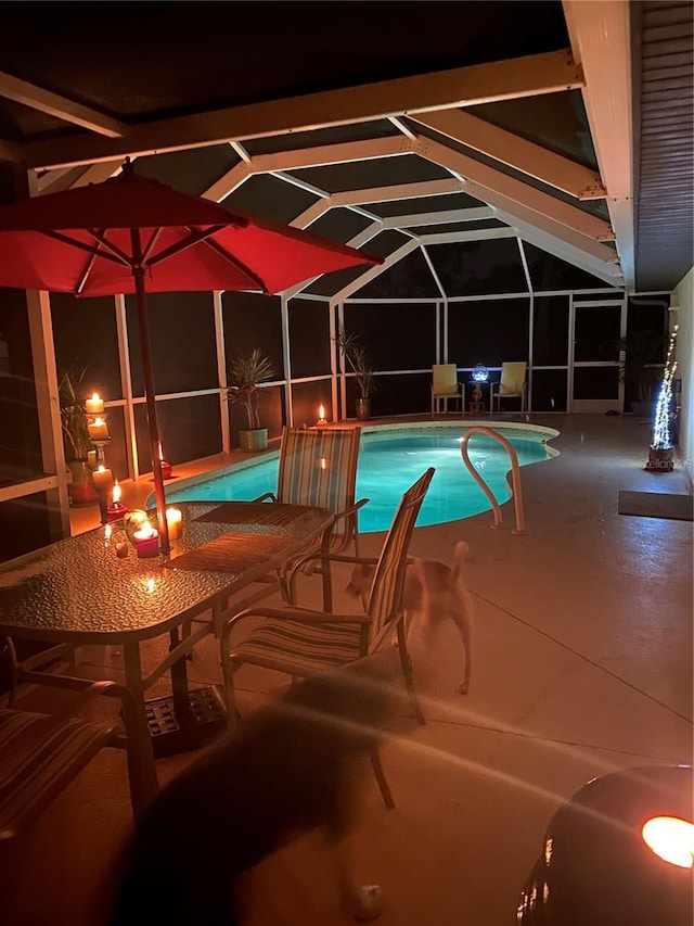 view of swimming pool featuring glass enclosure and a patio