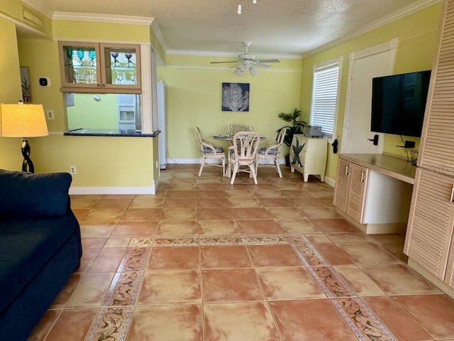 tiled living room featuring ceiling fan, ornamental molding, and a textured ceiling