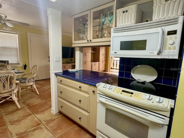 kitchen featuring tasteful backsplash, white appliances, ceiling fan, tile counters, and light tile patterned flooring