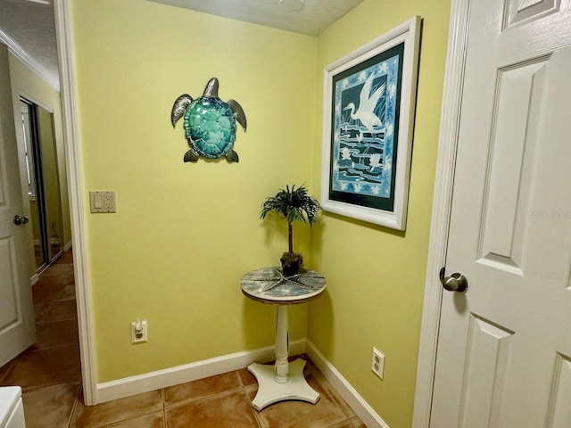 interior space with tile patterned flooring, ornamental molding, and a textured ceiling