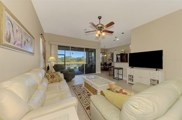 living room featuring light tile patterned flooring and ceiling fan with notable chandelier