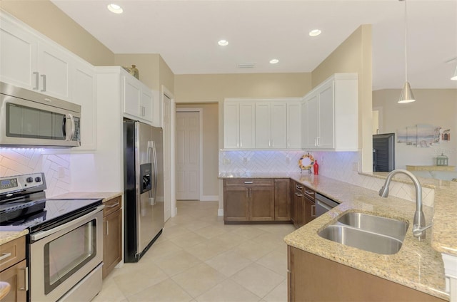 kitchen with sink, white cabinetry, stainless steel appliances, and hanging light fixtures