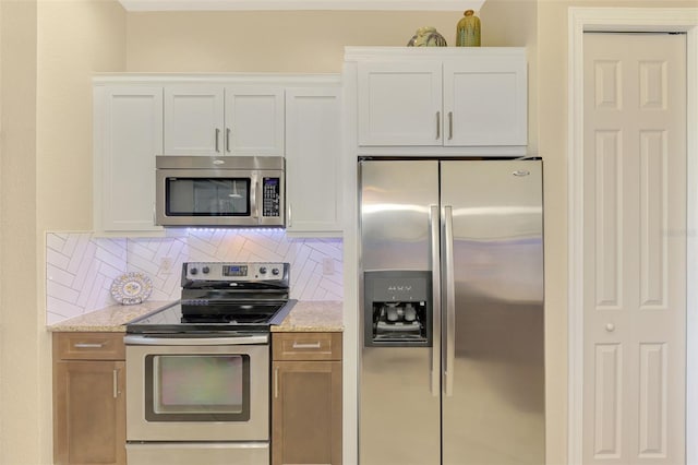 kitchen featuring light stone countertops, white cabinetry, and appliances with stainless steel finishes