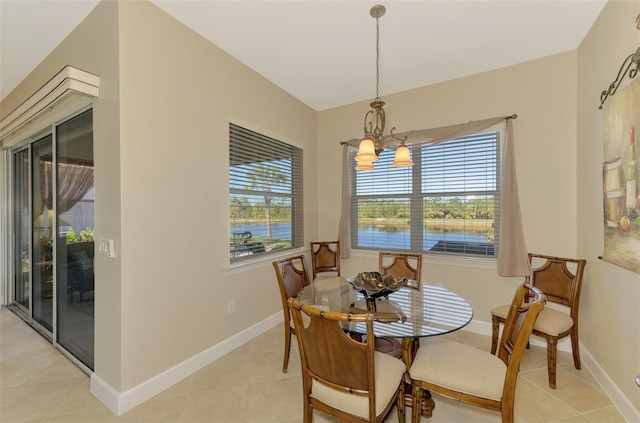 dining room with a water view, light tile patterned floors, and a chandelier