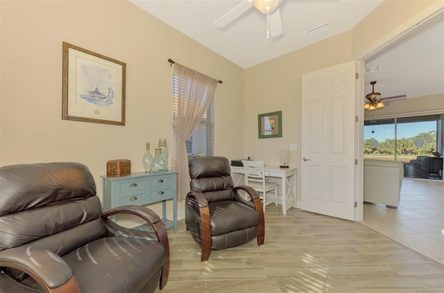 living area featuring ceiling fan, vaulted ceiling, and light wood-type flooring