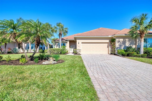 mediterranean / spanish home featuring a front yard and a garage