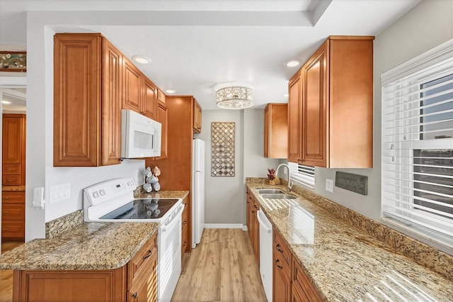 kitchen featuring light stone countertops, sink, light hardwood / wood-style floors, and white appliances